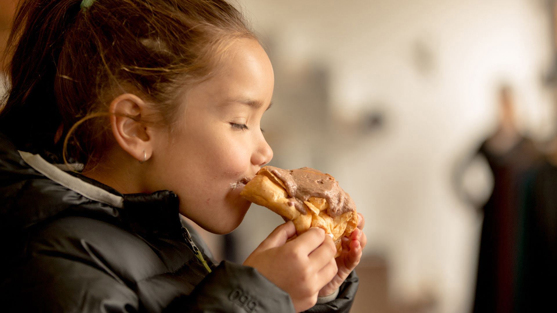 Girl eating chocolatea eclair from Johnny Nations Chocolate Eclair Shop Ohakune -Visit Ruapehu.jpg